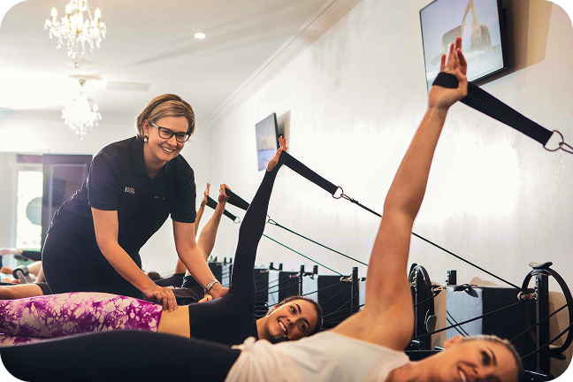 Pilates instructor guides her class through movements on the reformer.