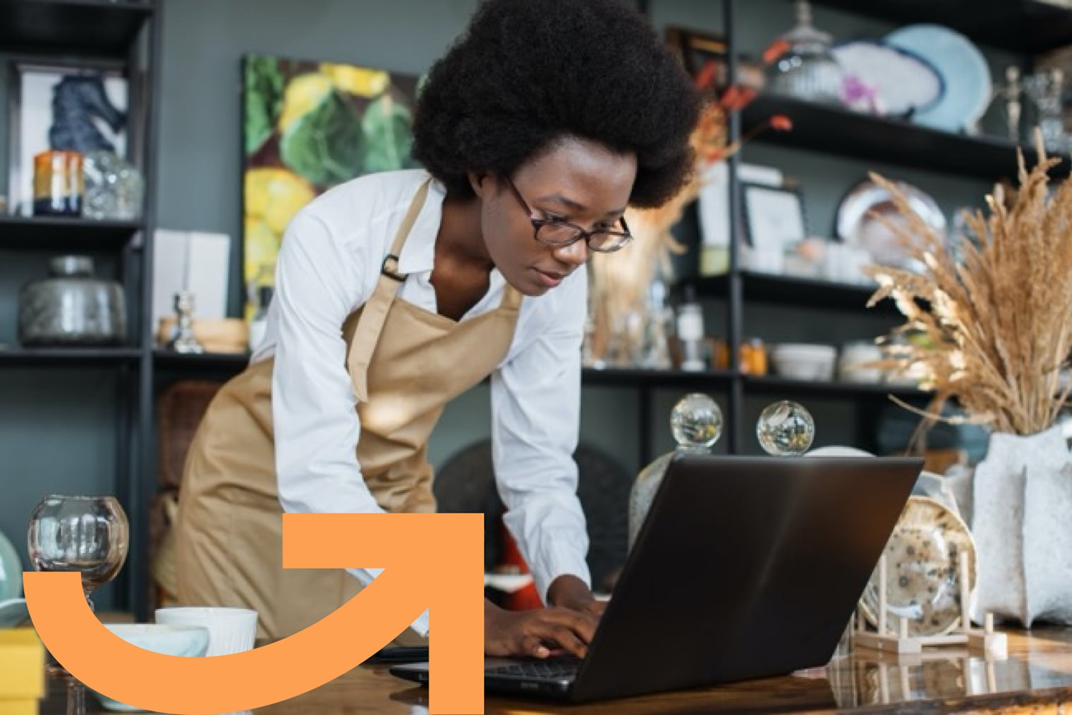 Small-business owner leaning forward to work on laptop