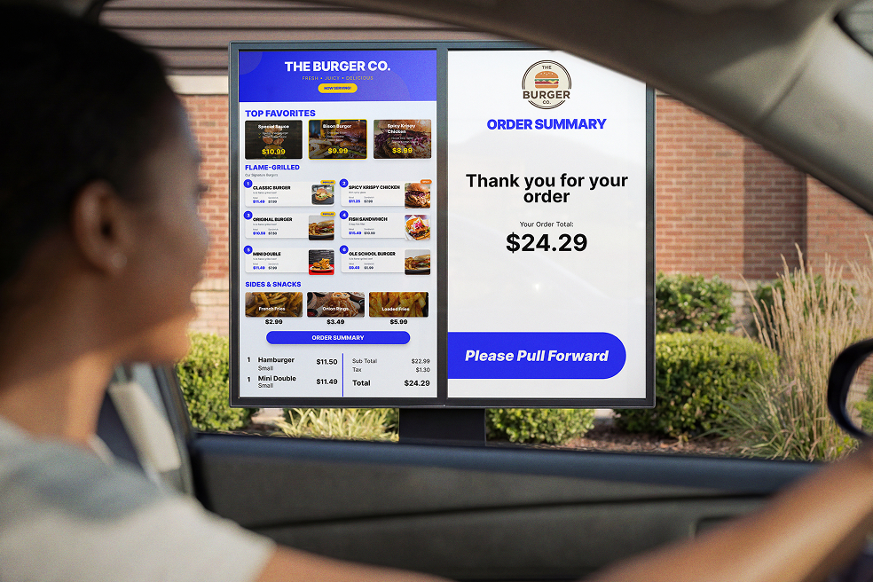 Customer in driver’s seat of car stopping in front of digital menu board at QSR