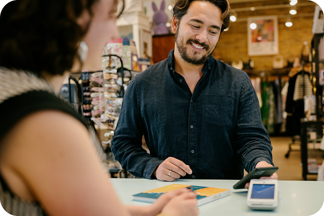 Image of customer using smartphone to make contactless payment at checkout