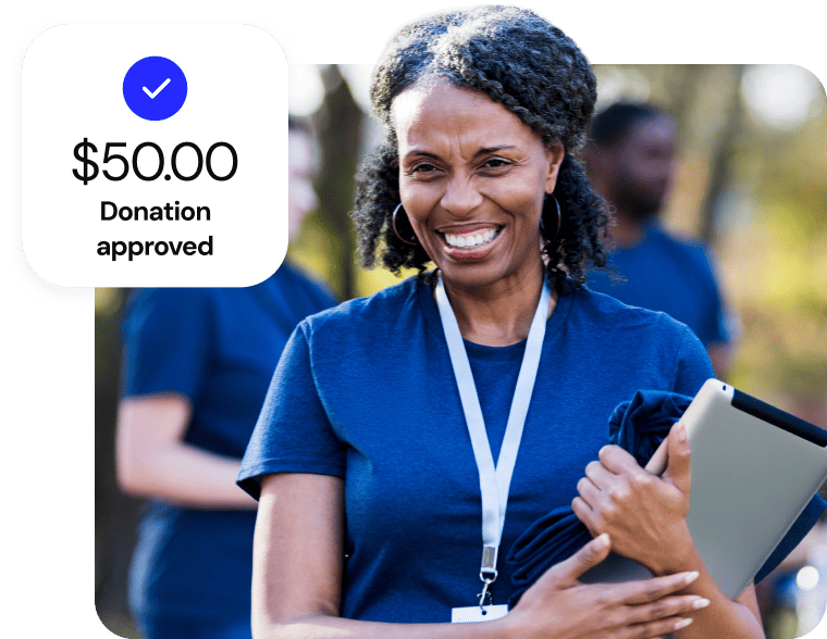 Female volunteer with a lanyard holding a tablet beside a $50.00 donation approved graphic.