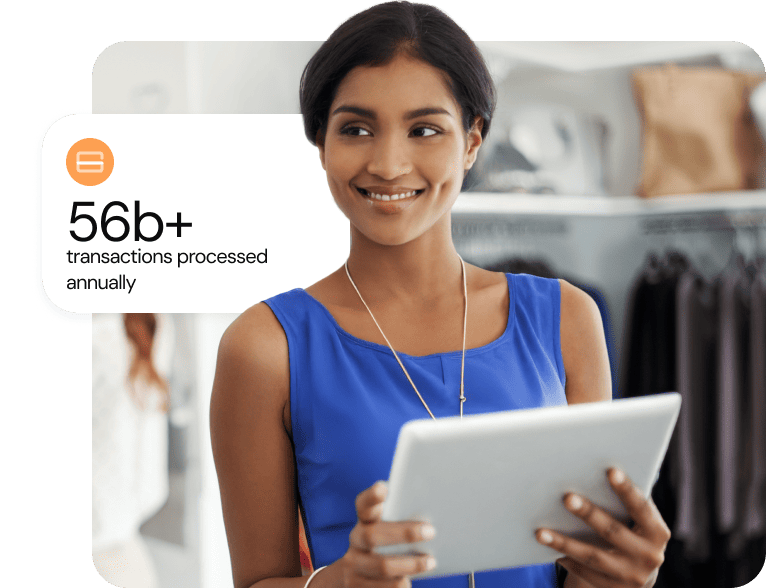 Woman working in retail environment looking at tablet and smiling