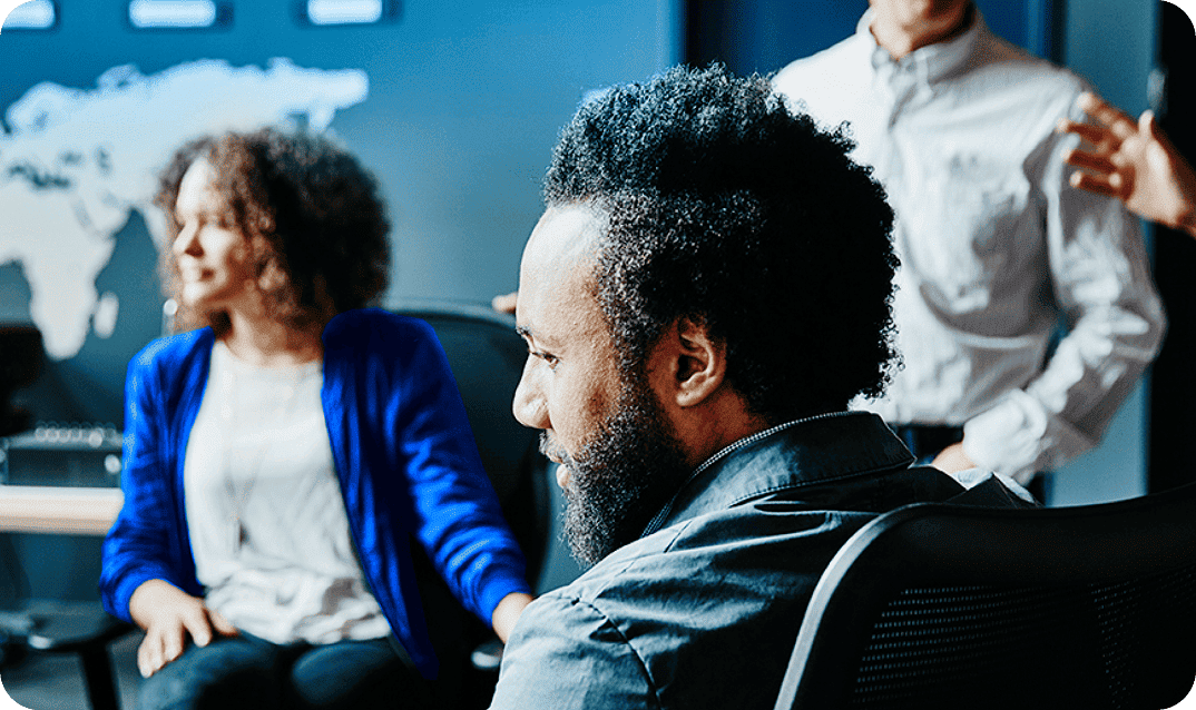 Profile of a bearded man listening during a business team meeting.