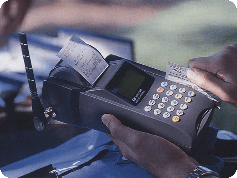 Close up of employee swiping card on wireless POS terminal