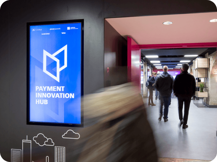 Two men walking down a hallway at Payment Innovation Hub conference