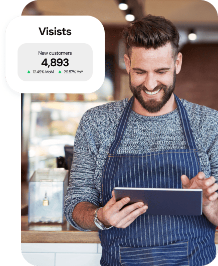 Man using a tablet next to a graphic showing "4,893 New customers" growth metrics