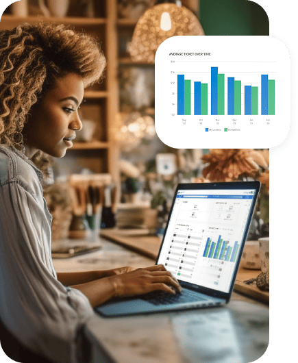 Profile of a woman with curly hair looking at business metrics on a laptop screen