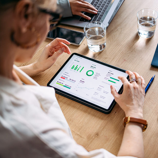Woman using a tablet to review financial dashboard data