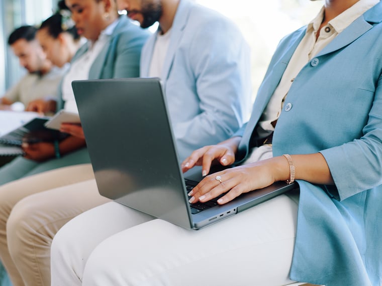 An employee works on her laptop during her break next to her coworkers.