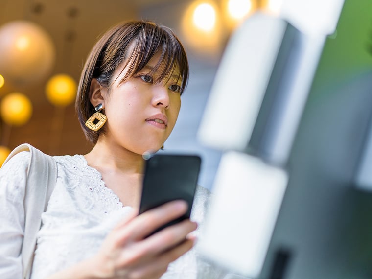 A customer holds a mobile phone.