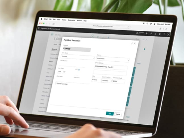 Close-up of hands working on a laptop with an open payment pop-up window.