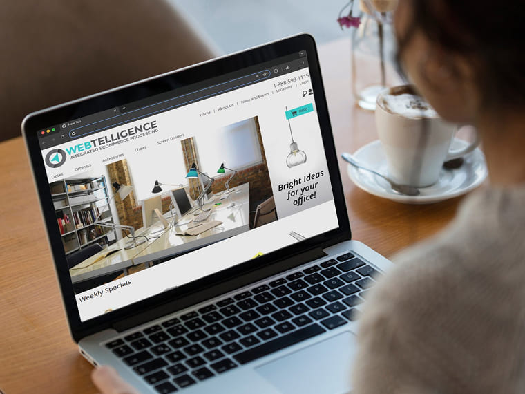 Woman using a laptop displaying an e-commerce website next to a cup of coffee.