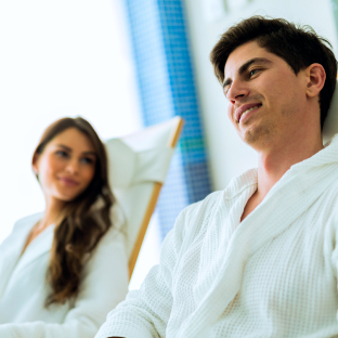 Deux clients en peignoir, allongés dans des chaises longues d'un spa.