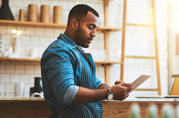 A restaurant owner checks his inventory from a mobile tablet.