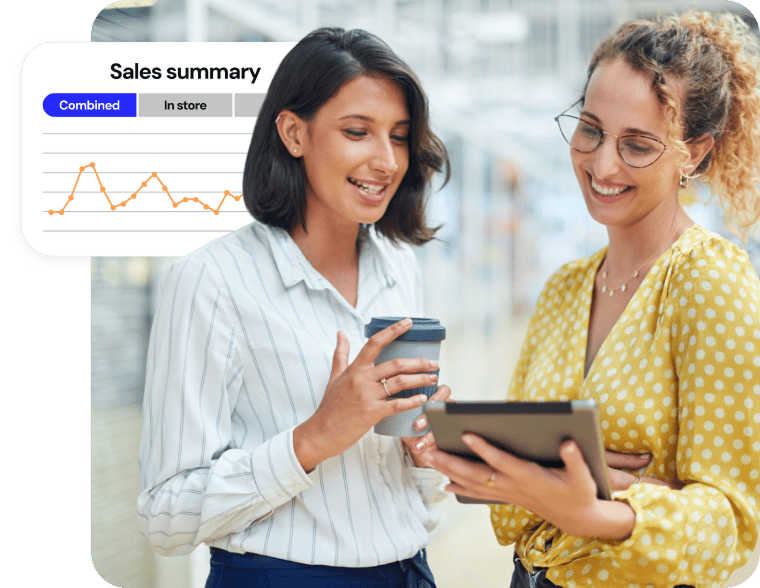 Two businesswomen looking at a tablet next to a sales summary graph overlay.