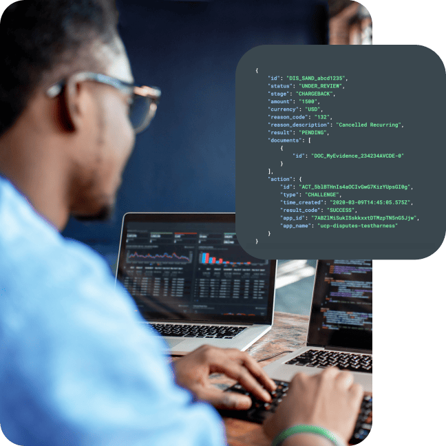 Person coding at dual laptops next to a highlighted JSON code overlay.