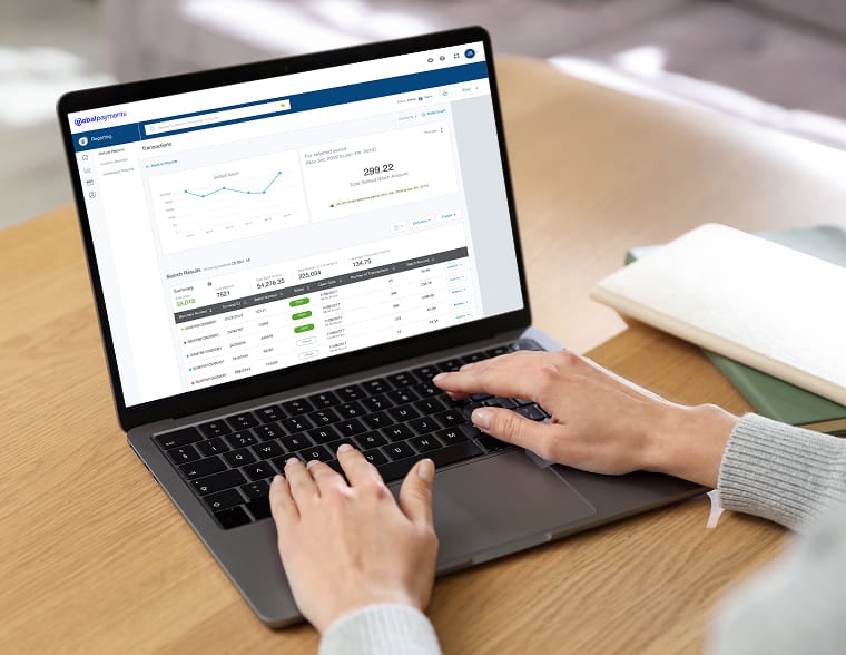 Close-up of a person using a laptop to review financial transaction reports and charts.