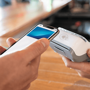 A mobile phone makes a payment on a portable card machine.