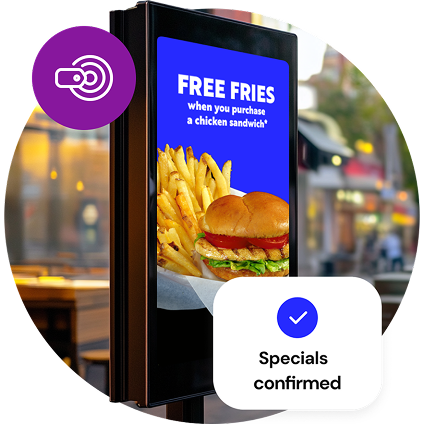 A freestanding, outdoor digital menu board shows a free fries special, while a small, purple circle graphic with a pricing icon overlays the image at the top and a graphic reading “Specials confirmed” overlays the bottom of the image.