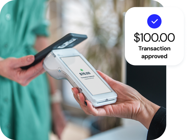 A person wearing a green shirt uses a smartphone to easily make a payment by tapping a Genius™ handheld device