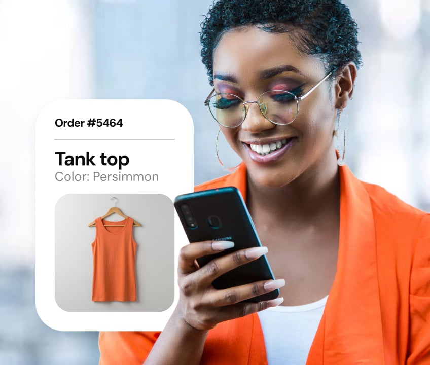 A smiling customer uses a mobile phone to check out a potential purchase on an online retail site