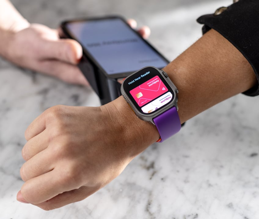 A customer quickly and easily makes a payment at a table by tapping a watch on a handheld terminal
