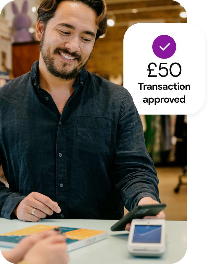 A smiling customer holds a smart phone up to a smart card reader with a caption reading “£ 50 Transaction approved.”