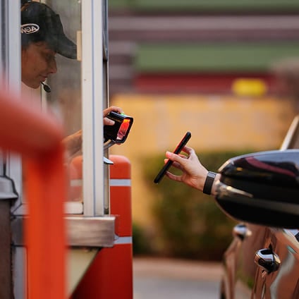 A customer receiving her order through her car window.