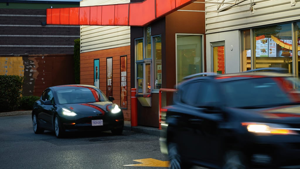 Two cars in drive thru at quick service restaurant
