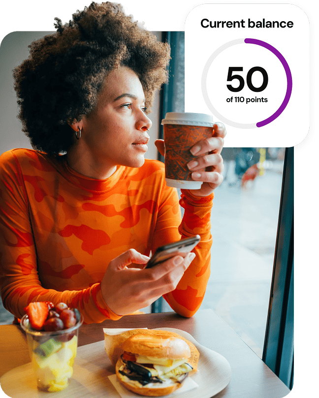 Woman holding coffee with a Current Balance 50 of 110 points graphic overlay