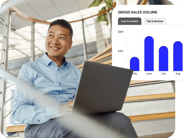 Man in an office environment sitting on stairs with laptop with chart displayed