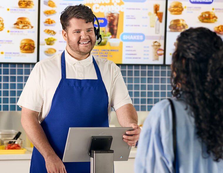 Young man with name tag smiling and working in quick service restaurant