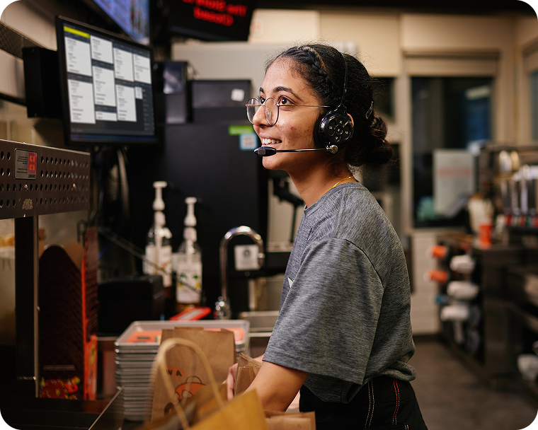 Un employé du service rapide prend une commande en cuisine.