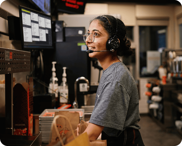 A quick service employee takes an order from back of house.
