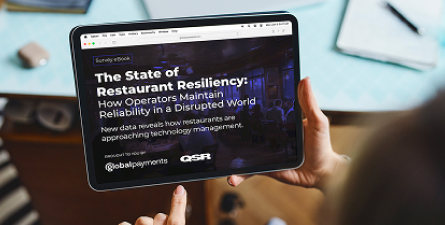 Person holding a tablet displaying a dark-themed QSR report cover titled “The State of Restaurant Resiliency.”