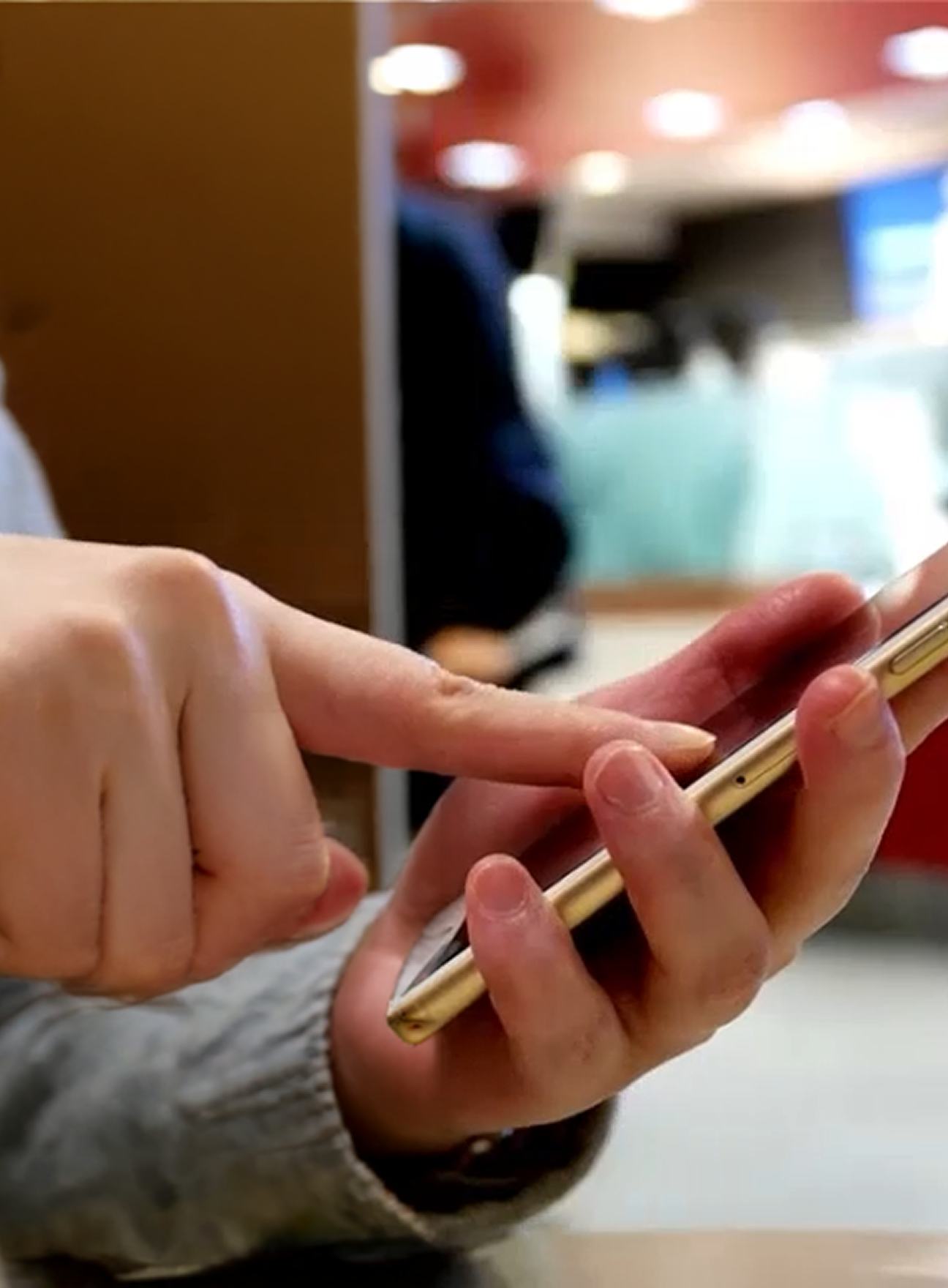 Close up of person typing on mobile phone in retail environment