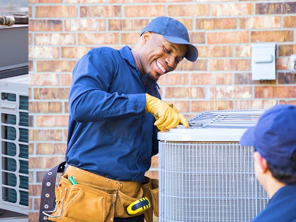 Un technicien en CVC assemble un climatiseur.