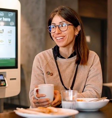 A corporate employee drinks coffee at a dining table.