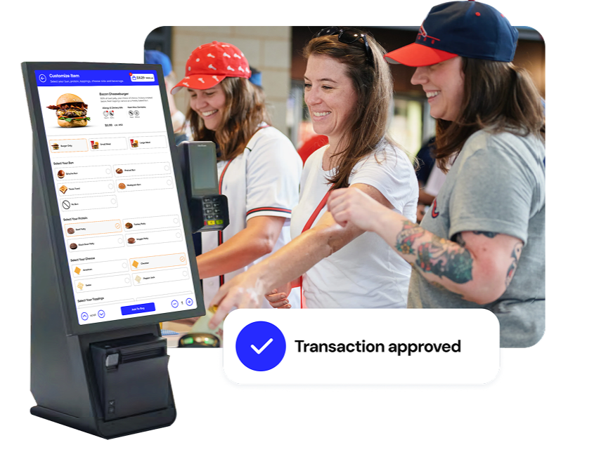 Genius kiosk with a self-ordering screen in front of a group of smiling fans ordering at a stadium