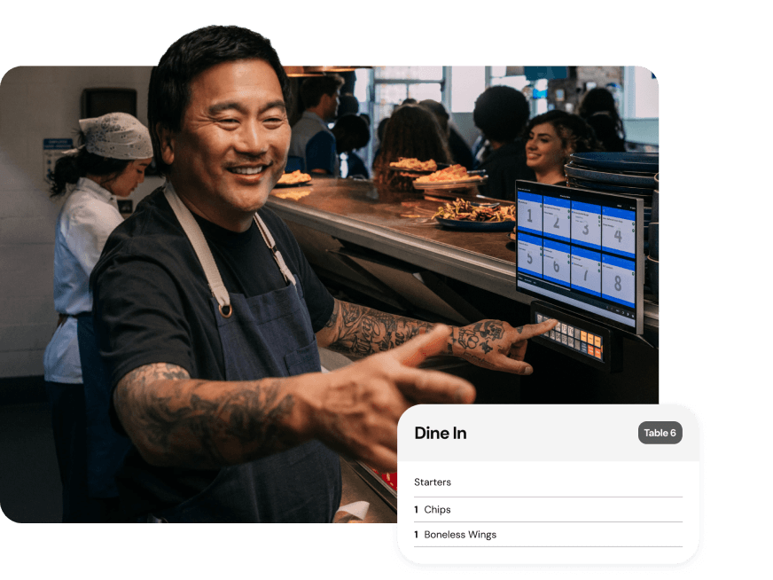 Man working in restaurant kitchen looking at digital order screen