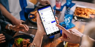 Employee using handheld device in restaurant setting