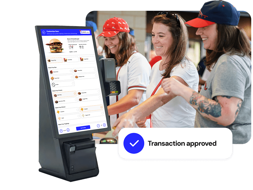 Genius kiosk with a self-ordering screen in front of a group of smiling fans ordering at a stadium