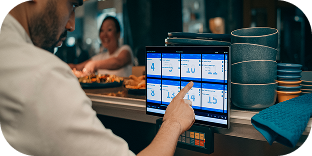 Kitchen employee scrolling through orders on Genius kitchen management tablet