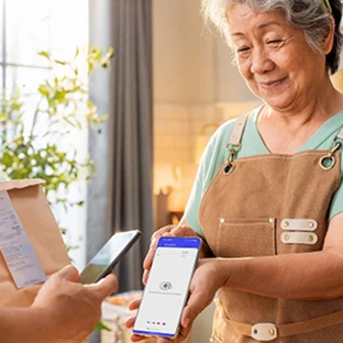 Flower shop employee holds out a Genius handheld point of sale for an offscreen customer to tap their phone to pay