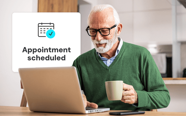 Older gentleman drinking coffee and looking at laptop with popup that says appointment scheduled