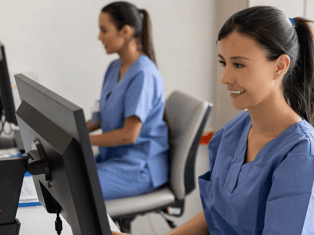 Healthcare worker sitting at desk working at computer in office