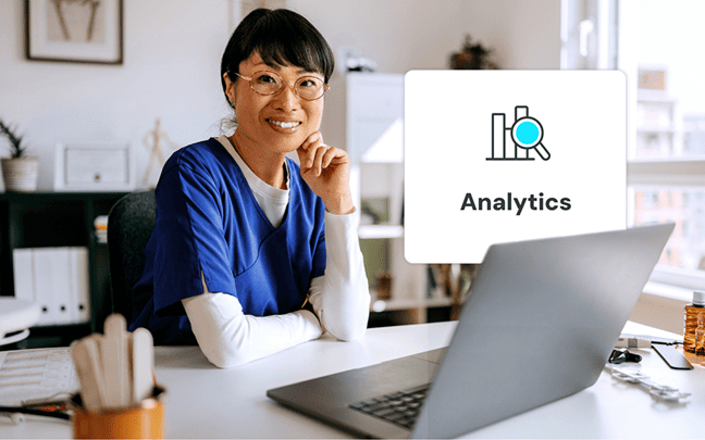 Healthcare worker smiling at desk with laptop and popup that says Analytics