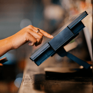 A customer touches a keypad on a POS after swiping a card.