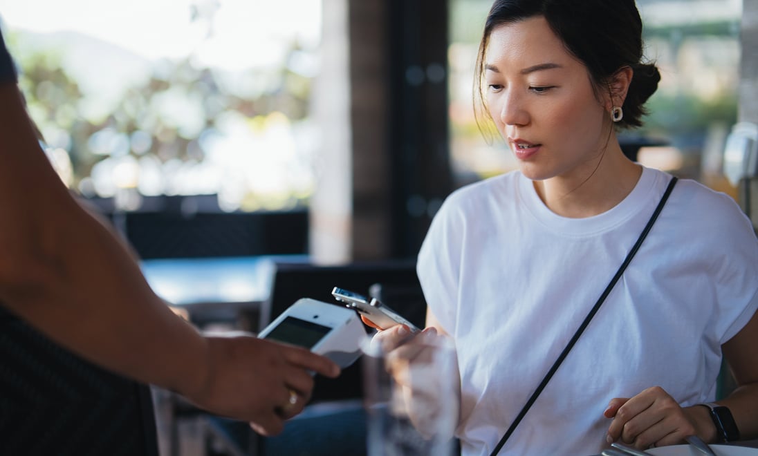 A customer checks out with a digital wallet at a mobile point of sale machine.