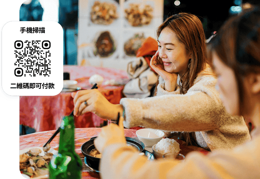 一群人於餐廳餐桌上共享美食，桌面可見可供手機支付的二維碼。